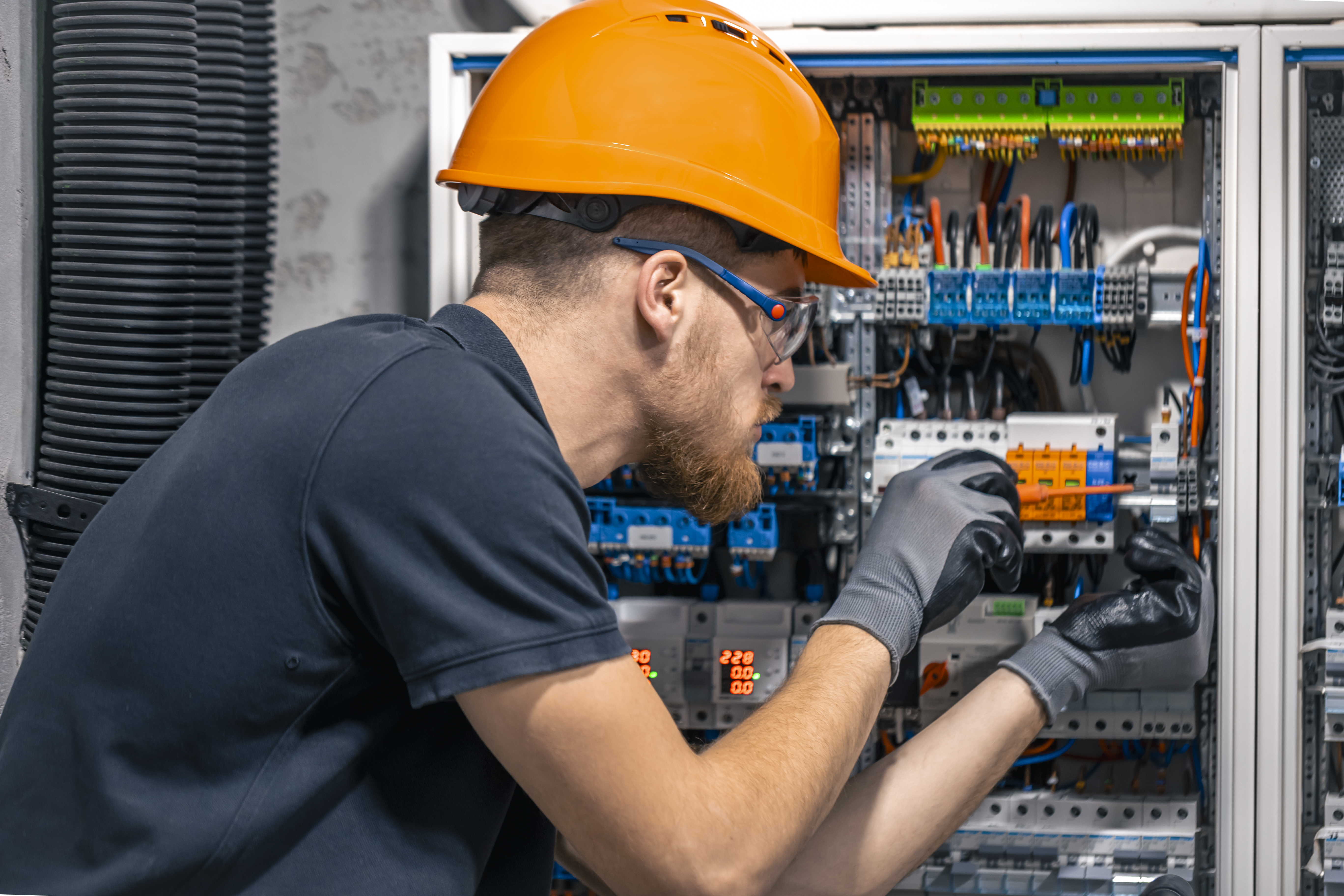 Electrician inspecting and testing a commercial switchboard